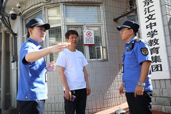 城管执法人员在检查中与值班老师进行沟通。 刘满清摄