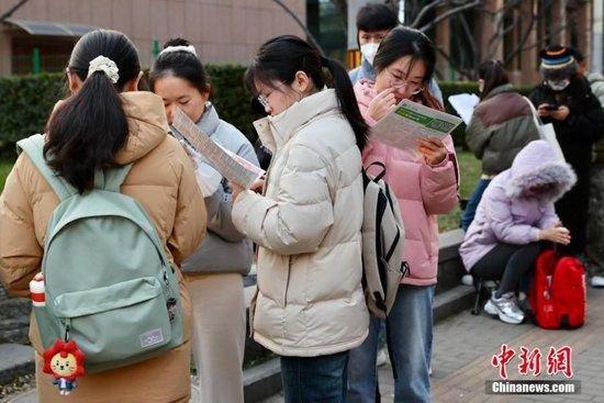 12月1日，北京首都师范大学附属丽泽中学初中部国考考点外，考生抓紧时间复习。中新社记者 易海菲 摄