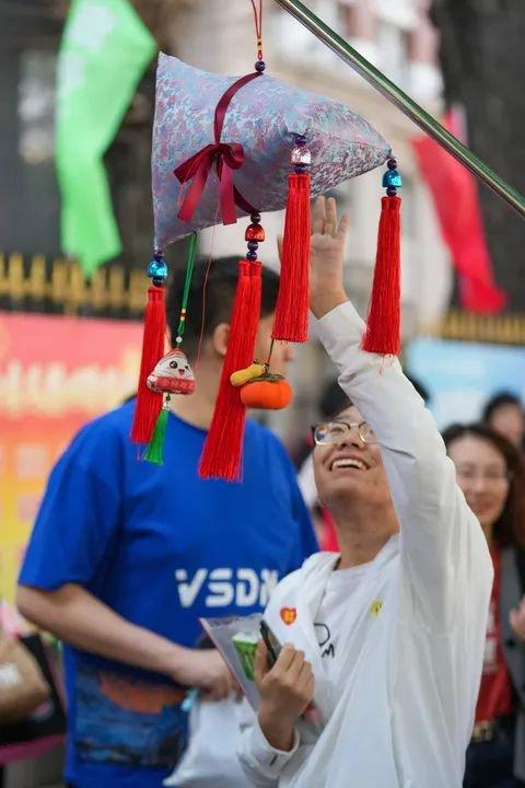 6月7日，在黑龙江哈尔滨市第九中学考点外，一名考生进入考场前伸手碰触“高粽”。新华社记者 王建威 摄