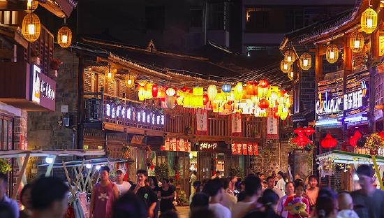 2023年7月27日，江西吉安，永丰县恩江古城，市民与游客漫步在灯火璀璨的街道上。图片来源：人民视觉