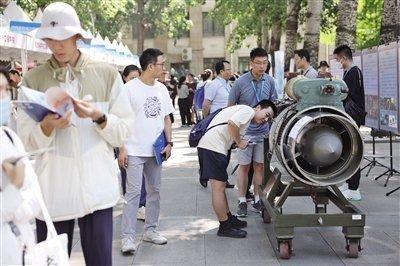 6月16日，北航校园开放日上，学生在近距离参观北航自行研发的航空发动机。