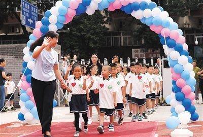 9月1日，方庄第二小学，新入学的一年级小学生穿过彩虹门步入校园。新京报记者 李木易 摄