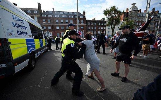 8月4日，英国警方与一名抗议者扭打在一起。