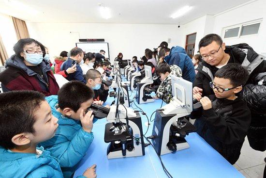 1月19日，哈尔滨医科大学校园开放，游客在医学形态学实验室通过显微镜观察人体的奥秘。