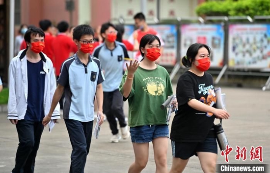 广西南宁考生佩戴印有“高考加油”字样的红色口罩走进考场。俞靖 摄