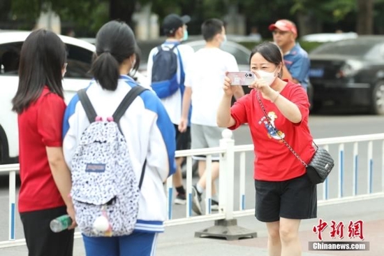 6月7日，北京市朝阳区，在北京工业大学附属中学考点，考生与家长合影留念。当日，2022年全国高考拉开帷幕。 中新社记者 蒋启明 摄