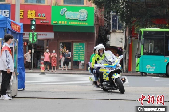 6月7日，一名考生忘记证件和文具，柳州交警机动大队民警刘华驾驶警用摩托车载着考生家长飞奔在路上。受访者提供