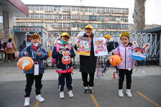 2月6日，开学首日，山东省济南市经十一路小学的部分学生，在校门口展示自己的兔年文创作品。（受访单位供图）