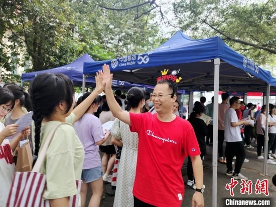 6月8日，广西柳州市第六中学的高考考点，送考老师卢武与考生击掌加油鼓励。受访者提供