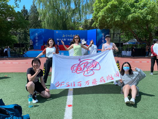 今年4月22日，王珂（中）参加完学校运动会1500米项目后与社团成员合影。受访者供图